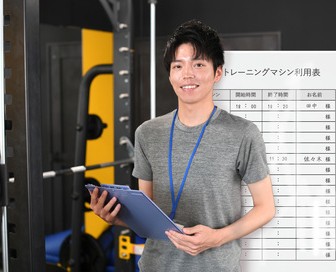 ホワイトボードでスポーツジムの利用者を管理しているスタッフ
