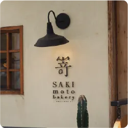 黒い照明ランプの下に配置されたパン屋の切り文字看板