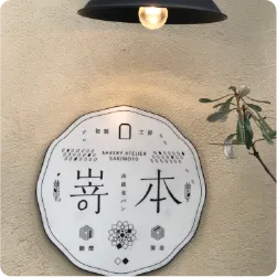 壁面に設置された丸型の店舗ロゴ看板