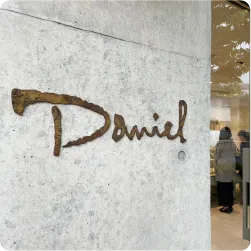 コンクリート壁に設置された錆風ロゴ看板