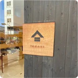 木製プレートにロゴと店名を記載した表札看板