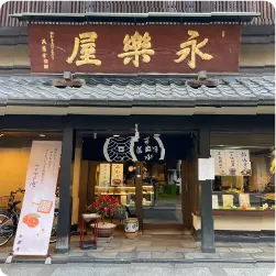 木製の店舗看板が掲げられた和菓子店の外観