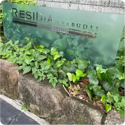 植栽に設置された半透明プレートのマンション看板