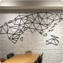 白いレンガ壁に設置されたワイヤーアートの世界地図ウォールサイン