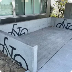 コンクリート壁面に自転車のピクトグラムを描いた駐輪スペースのサイン