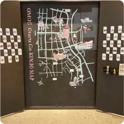 黒い壁に描かれた手書き風イラストの大きな観光マップ