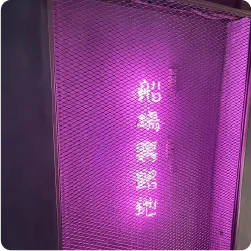 金網の内側で光って隠れ家風の雰囲気を演出する、飲食店街のネオンサイン