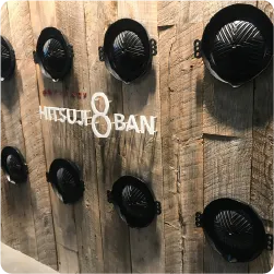 木壁にジンギスカン鍋を装飾し、中央に切り文字サインを配置した看板演出