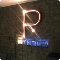 レンガ壁に設置された光る「Ｒ」の文字のサイン