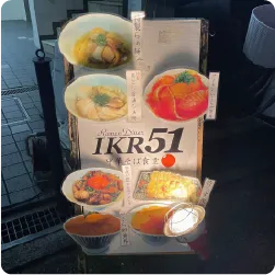 切り取ったメニュー写真を貼ったラーメン店のスタンド看板