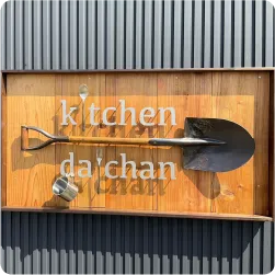 木製ボックス内にスコップやコップを立体展示した飲食店の壁面看板